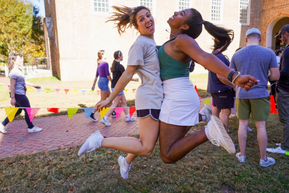 two students joyfully jumping into each other