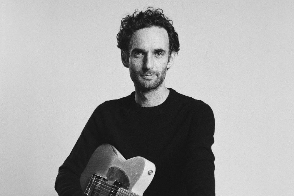 Julian Lage holding a guitar