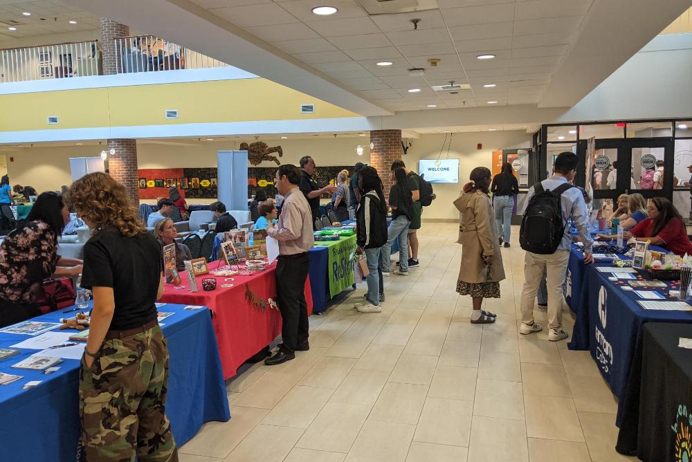 Attendees talking to community organizations at the annual volunteer fair in the Sadler atrium