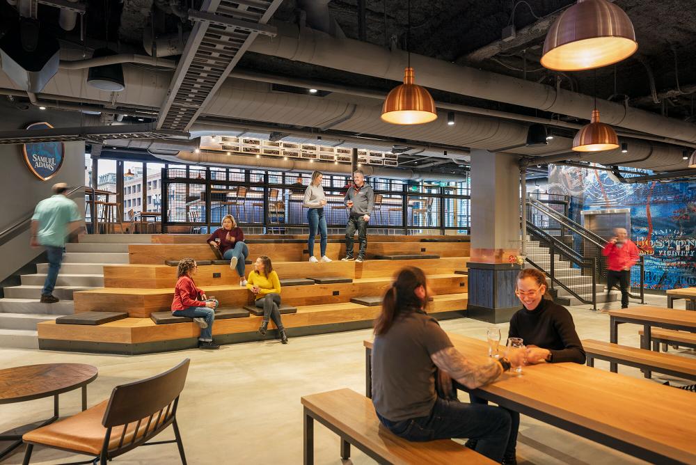 Pictured: group of people in venue chatting with each other and seated throughout the room.