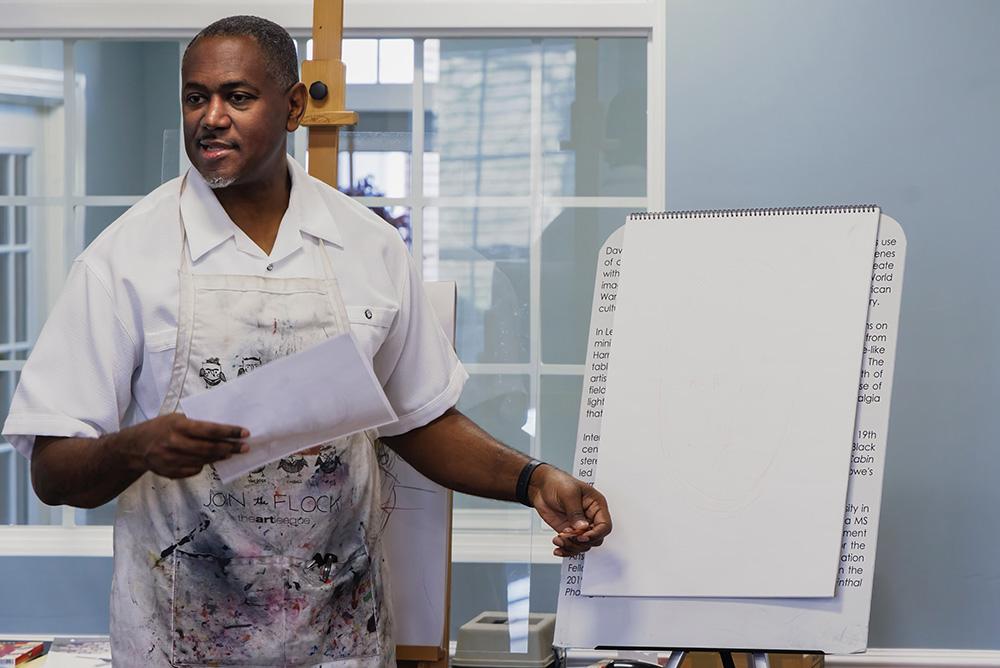 Steve Prince stands in front of an easel during an art-making workshop.