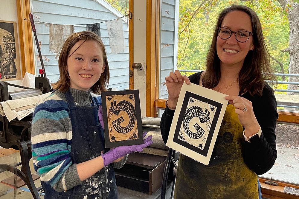 A student intern and workshop participant demonstrate the cut linoleum plate and the resulting print made during the Art of the Book workshop.