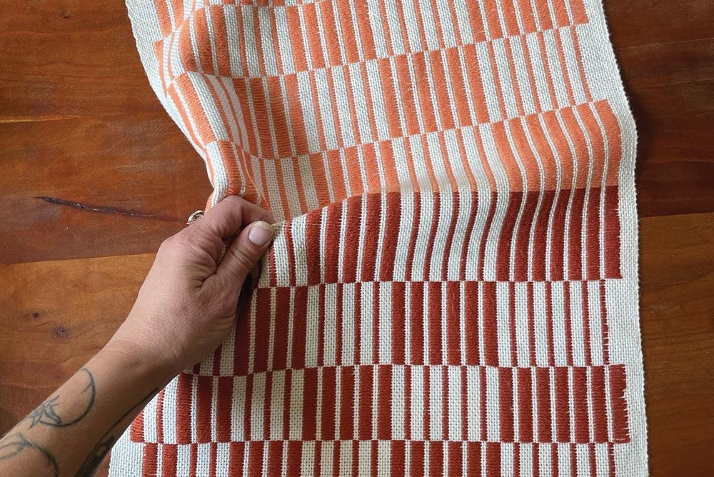 A woven table runner crafted by weaver Kate Koconis
