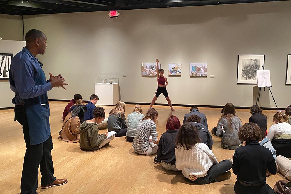 Student drawing a live model in charcoal