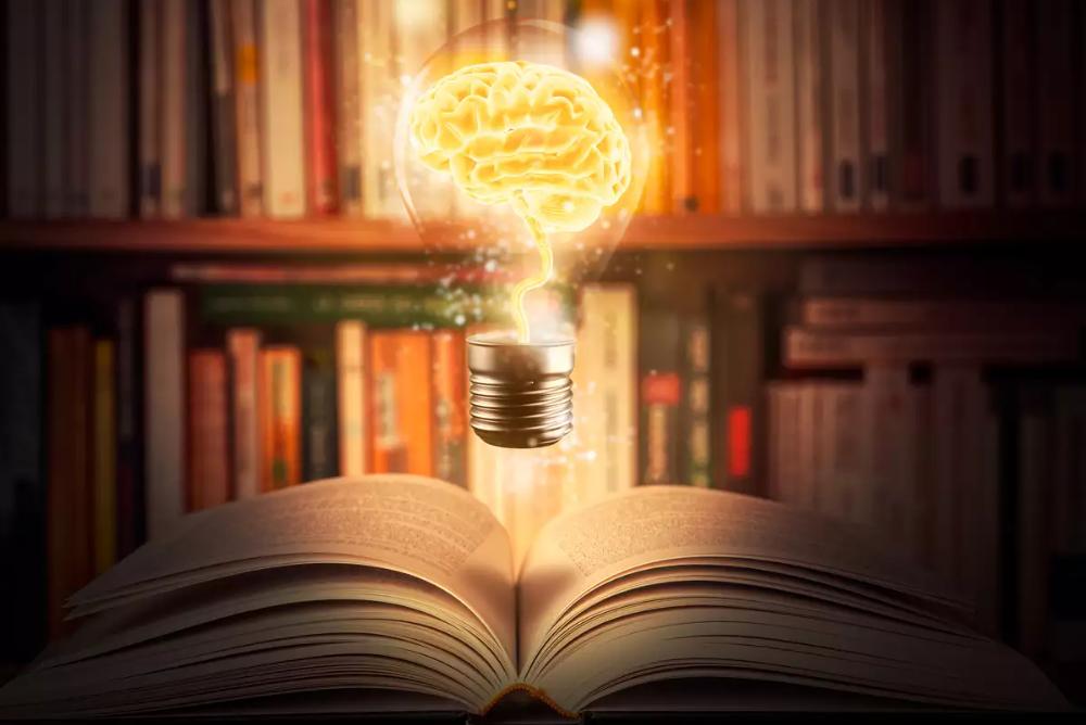 Book with a light bulb above it and books in the background