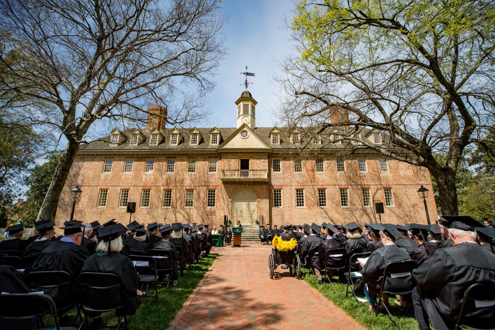 Wren Yard with seated Olde Guarde inductees in black graduation robes